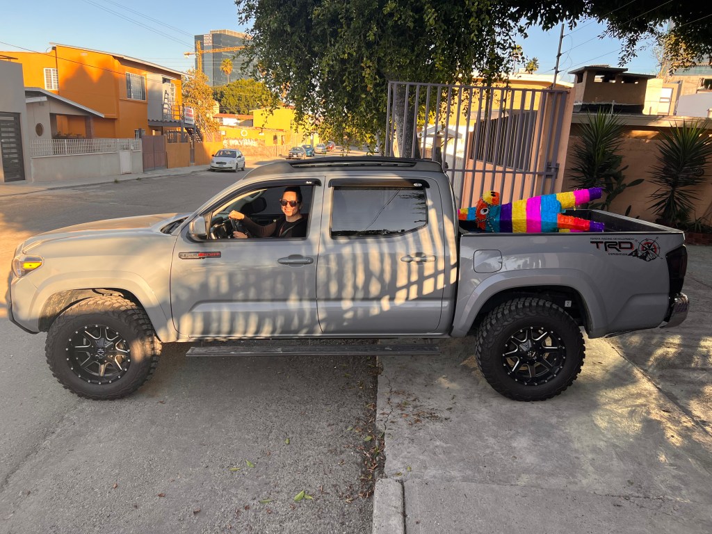 Arlene Bayliss al volante de una camioneta en Tijuana, con una piñata en la parte trasera