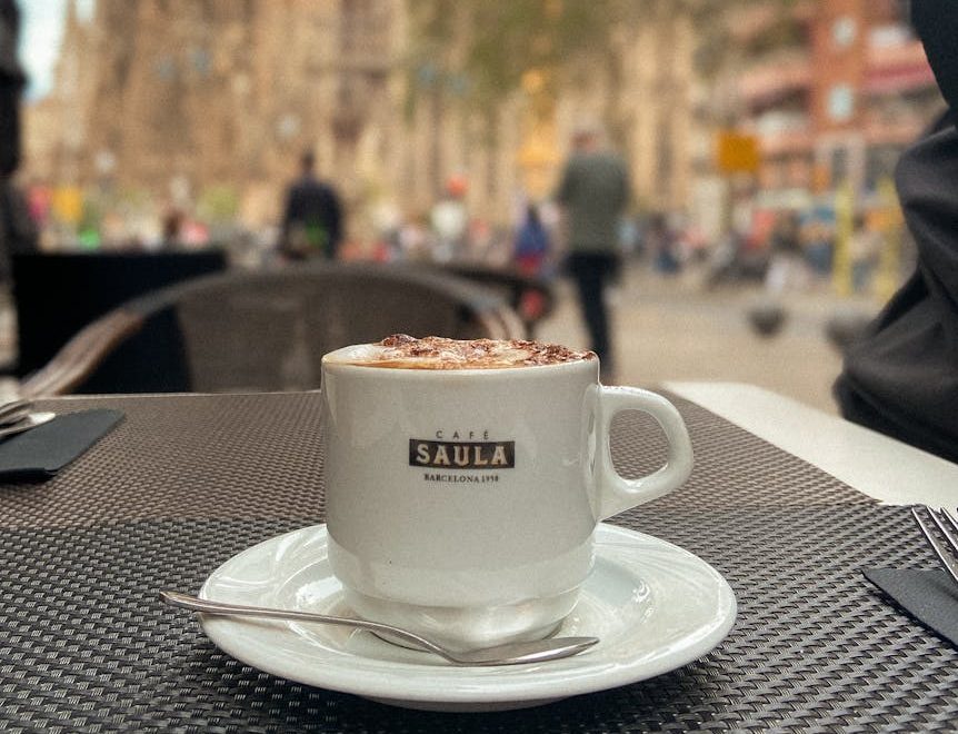 Taza de café en una terraza con la Sagrada Familia al fondo, una pausa cotidiana en Barcelona