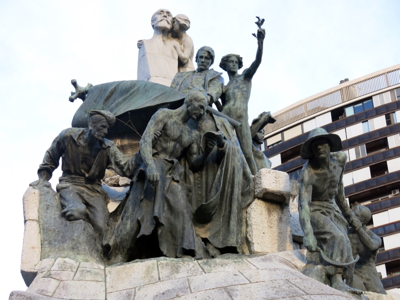 Escultura en piedra y bronce del monumento al Doctor Robert, con figuras alegóricas que representan al pueblo