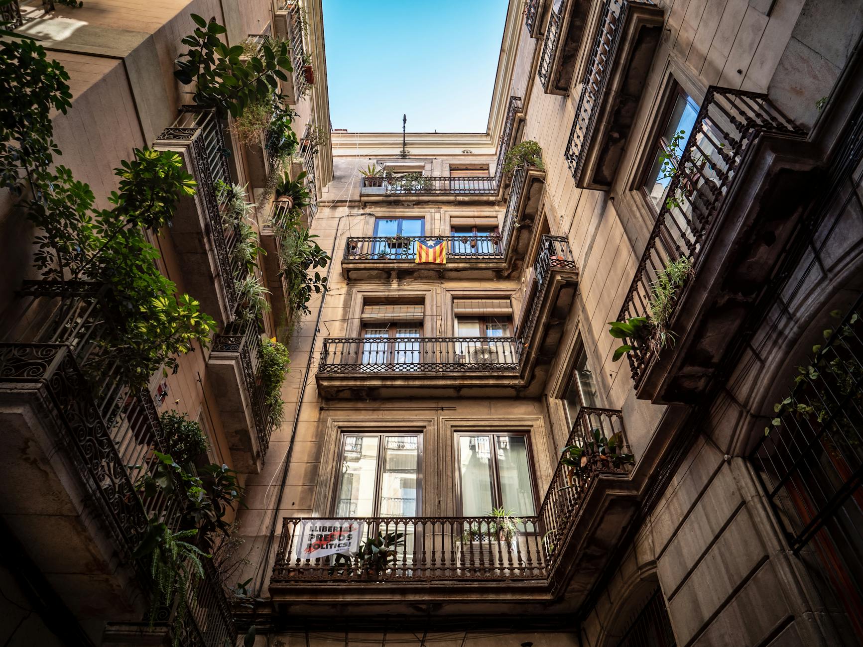 Fachadas de edificios residenciales en Barcelona con balcones cerrados y persianas bajadas, reflejo de la crisis de vivienda y la gentrificación urbana