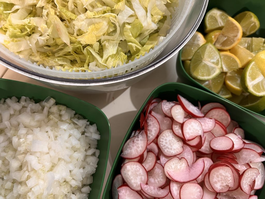 Ingredientes frescos sobre una mesa: col, rábano, cebolla y limón, preparación de comida mexicana en casa