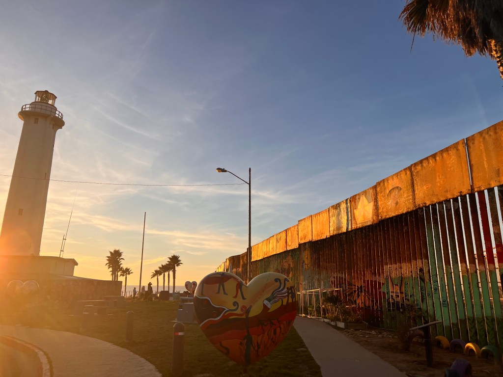 Muro fronterizo entre Tijuana y San Diego junto al faro de Playas de Tijuana al atardecer